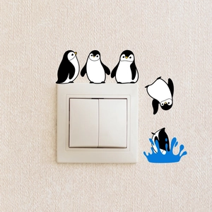 Detail of cartoon penguin wall stickers around a light switch on textured wallpaper