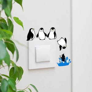 Detail of creative penguin wall stickers showing diving motion around a white light switch
