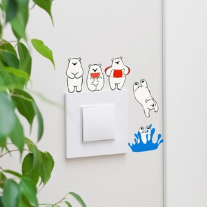 Macro detail of cartoon polar bear switch stickers on a white wall background