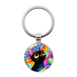 Dettaglio portachiavi con gatto nero e galassia colorata su sfondo bianco con finitura argento