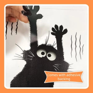 Detail of hand peeling cartoon black cat wall sticker with adhesive backing and claw marks