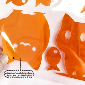 Close-up of orange cartoon cat and fish glow wall stickers with self-glow property