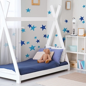 Detailed view of blue starfish wall decals with white polka dots in a cozy nursery