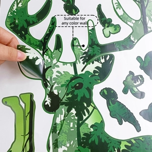 Detail showing hand peeling a forest deer wall sticker to demonstrate its thin vinyl material