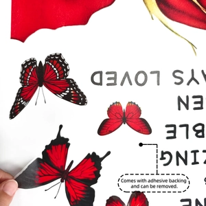 Detail of red butterfly wall sticker showing self-adhesive backing and easy removal