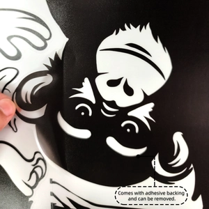 Detail showing the flexible adhesive backing of a black gorilla wall sticker being peeled