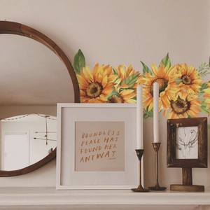 Detail of sunflower wall stickers in hand-painted watercolor style on a white bedroom wall