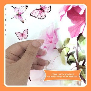 Detail showing hand peeling a removable pink floral wall sticker with adhesive backing