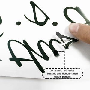 Detail of double-sided adhesive wall sticker showing transparent texture and handwriting style