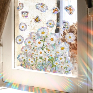 Raamstickers met madeliefjes en vlinders met regenboogeffect en prismatische breking