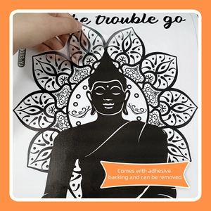 Detail of self-adhesive black mandala lotus wall sticker being peeled by hand