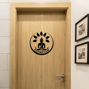Detail of black Buddha silhouette wall sticker with lotus pattern on a light wooden door