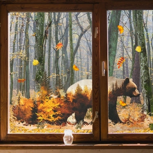 Detail of double-sided autumn forest bear window cling with maple leaves on glass