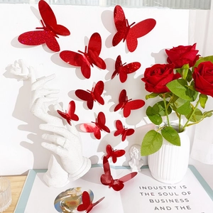 Detalle de pegatinas de pared de mariposas 3D rojas con purpurina en una pared blanca pura