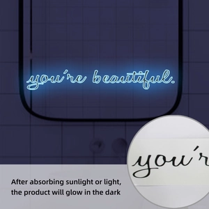 Luminous wall sticker showing you're beautiful phrase glowing blue in dark bathroom