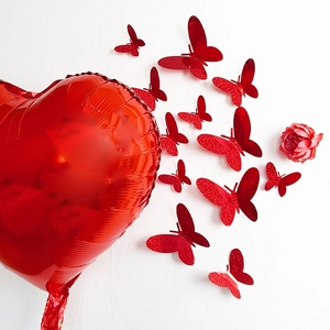 Detalle de globo de corazón rojo y pegatinas de pared de mariposas 3D con purpurina