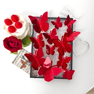 Detalle macro de mariposas 3D rojas con purpurina para decoración de bodas