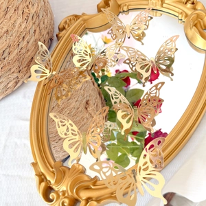 Close-up of golden hollow butterfly wall stickers with mirror effect on vintage frame