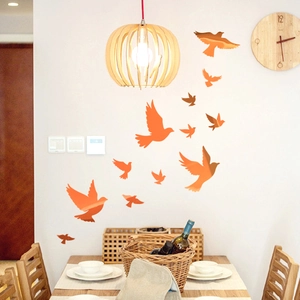 Glow-in-the-dark orange bird wall decals in a warm dining room scene with wooden decor