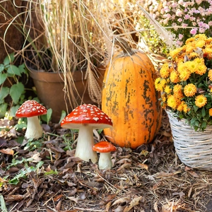 Drei rote Fliegenpilz Gartenstecker mit weißen Punkten in herbstlicher Szene