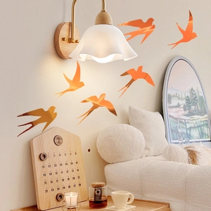 Detail of gradient orange swallow wall stickers in a cozy living room decor setting