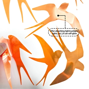 Close-up of orange swallow wall decals showing luminous self-glow material and texture