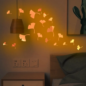 Luminous orange ginkgo leaf wall stickers glowing in a cozy bedroom setting