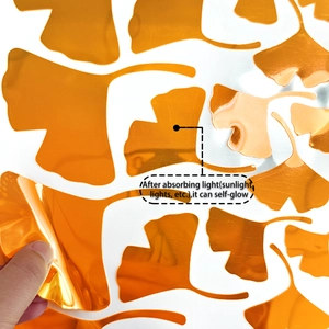 Close-up of luminous orange ginkgo leaf wall stickers with self-glow feature demonstration
