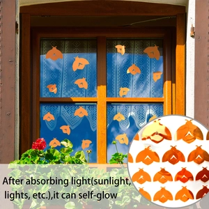 Detailed view of orange luminous moth stickers with self-adhesive glow on windows