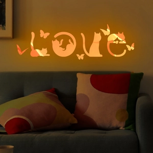 Close-up of orange luminous cat and butterfly wall sticker in a cozy living room scene