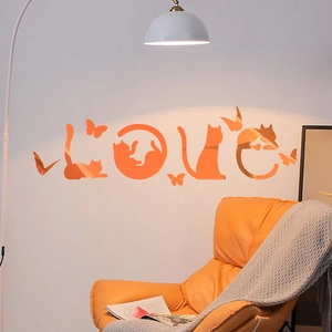 Close-up of orange acrylic LOVE wall stickers with cat silhouettes and mirror reflection