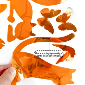 Close-up of luminous orange cat and butterfly wall stickers with metallic mirror finish