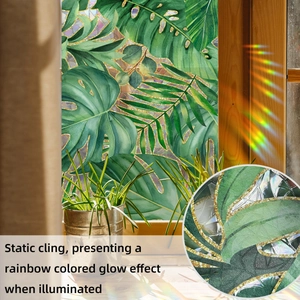 Close-up of tropical green leaf window film showing static cling and rainbow glow effect