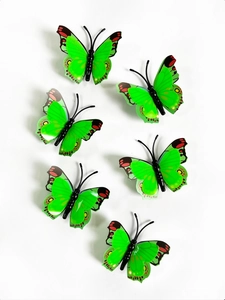 Close-up of set of six green 3D double-layered decorative butterflies on white background