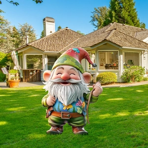 Garden gnome decoration with pointed hat and walking stick standing on outdoor lawn