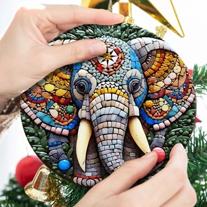 Close-up of a colorful mosaic elephant garden ornament held against a festive background