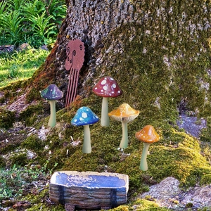 Set of five colorful PVC mushroom garden stakes with white polka dots for outdoor decoration