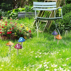 Detailed view of colorful mushroom garden stakes set of 5 on a green lawn