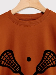 Detail of ribbed neckline and black Lacrosse print on a burnt orange sweatshirt