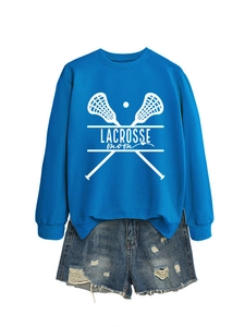 Flat lay of royal blue Lacrosse Mom sweatshirt paired with distressed denim shorts