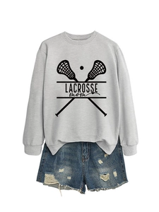 Detail of grey Lacrosse Mom sweatshirt with denim shorts set on a plain white background