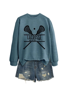 Flat lay of blue grey Lacrosse Mom sweatshirt with ripped denim shorts on white background