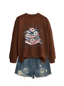 Close-up of graphic sweatshirt print with books and flowers on dark brown fabric