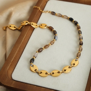 Collier élégant en pierres naturelles et maillons grains de café dorés sur satin