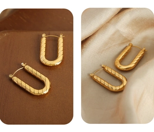 Detailed view of U-shaped gold earrings featuring diagonal textured patterns and latch closure