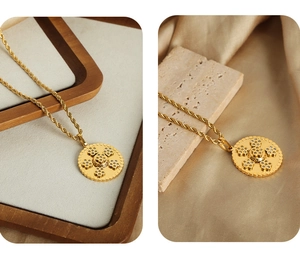 Détail macro du pendentif doré avec motif Greca et oxydes de zirconium sur chaîne torsadée