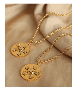 Vue macro du pendentif doré avec cristaux et motif grec sur fond de tissu en soie