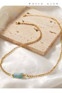 Dettaglio della collana placcata oro con pendente in pietra blu su seta di lusso