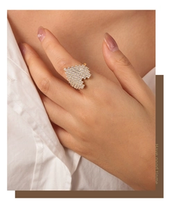 Detail of gold-plated pixel heart ring with paved zirconias worn by a model
