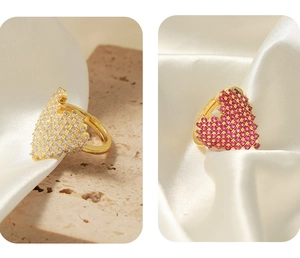 Close-up of heart-shaped adjustable copper rings with white and pink zircon crystals